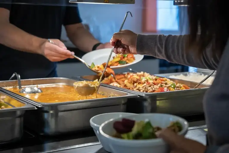 To personer forsyner seg med varm mat og suppe i Løvetann Kantine